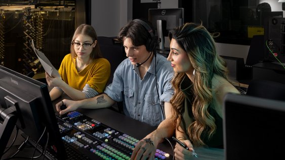 Drei Studierende sitzen am PC