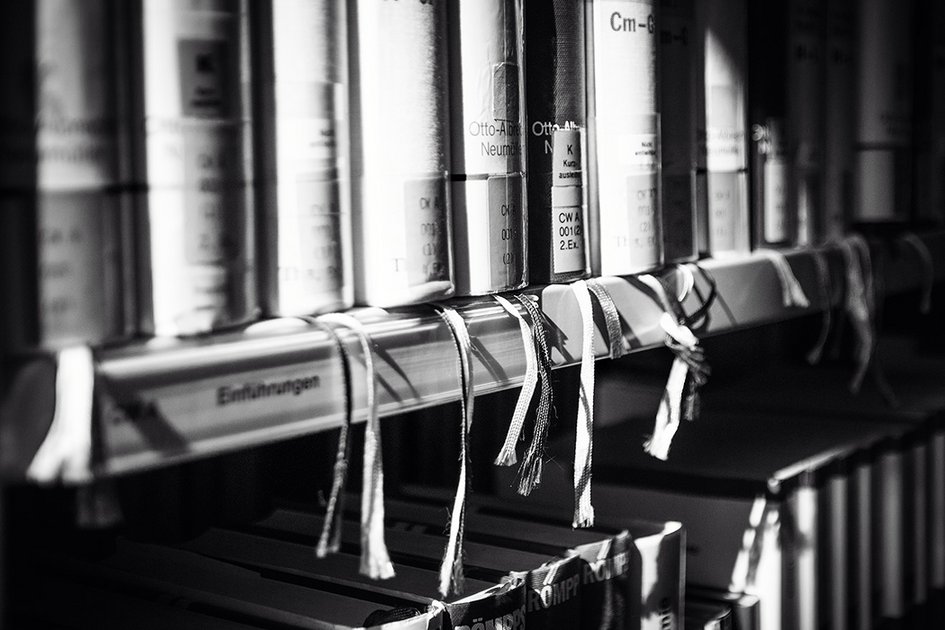 Ausschnitt eines gefüllten Bücherregals in schwarz-weiß