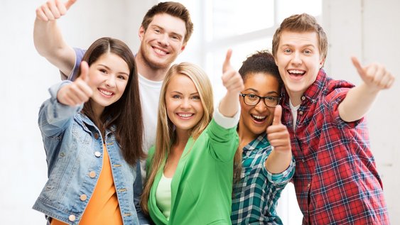 Studentinnen und Studenten zeigen jubelnd Daumen hoch