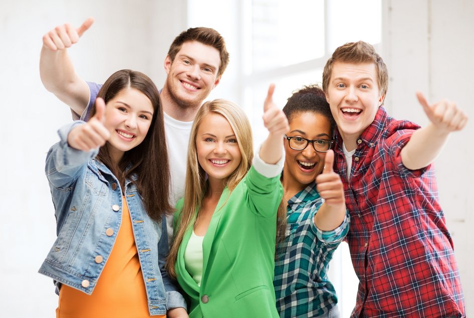Studentinnen und Studenten zeigen jubelnd Daumen hoch